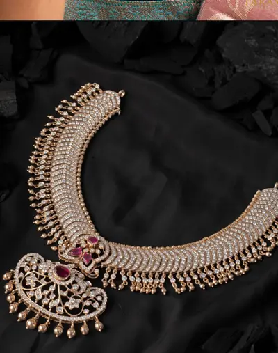 A diamond haram with a large paisley pendant on black cloth.