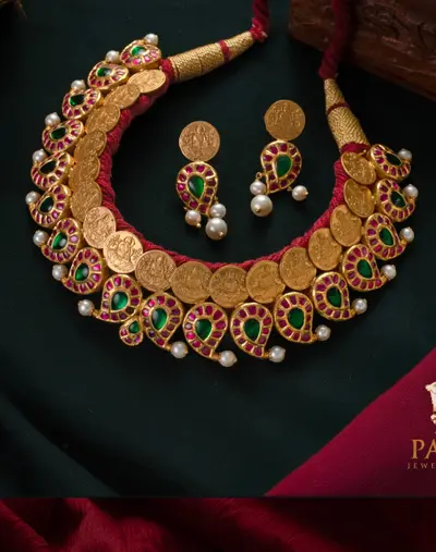 A coin kasumala necklace with red and green kemp drops and earrings.